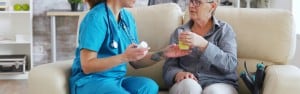 Ältere Frau bekommt im Rahmen der Behandlungspflege Medikamente